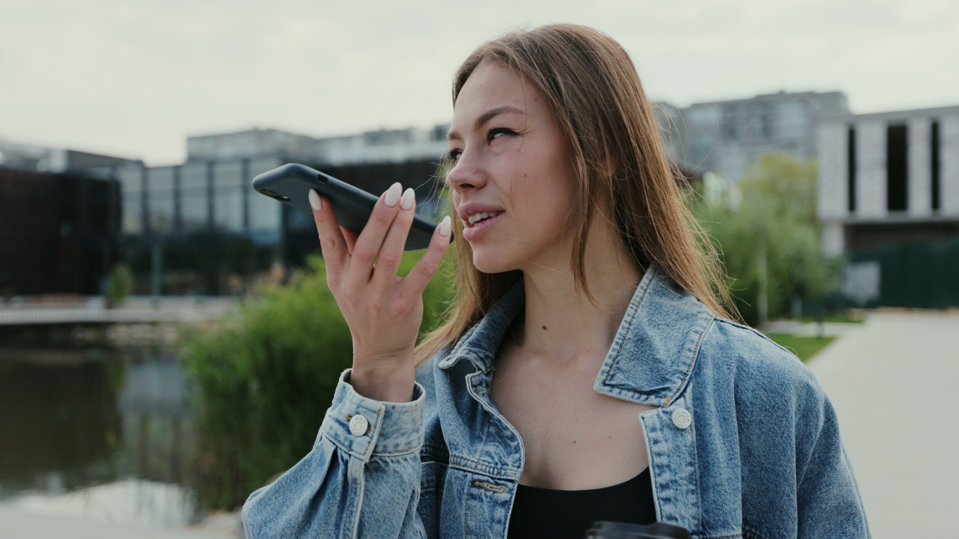 women speaking into phone, voice search